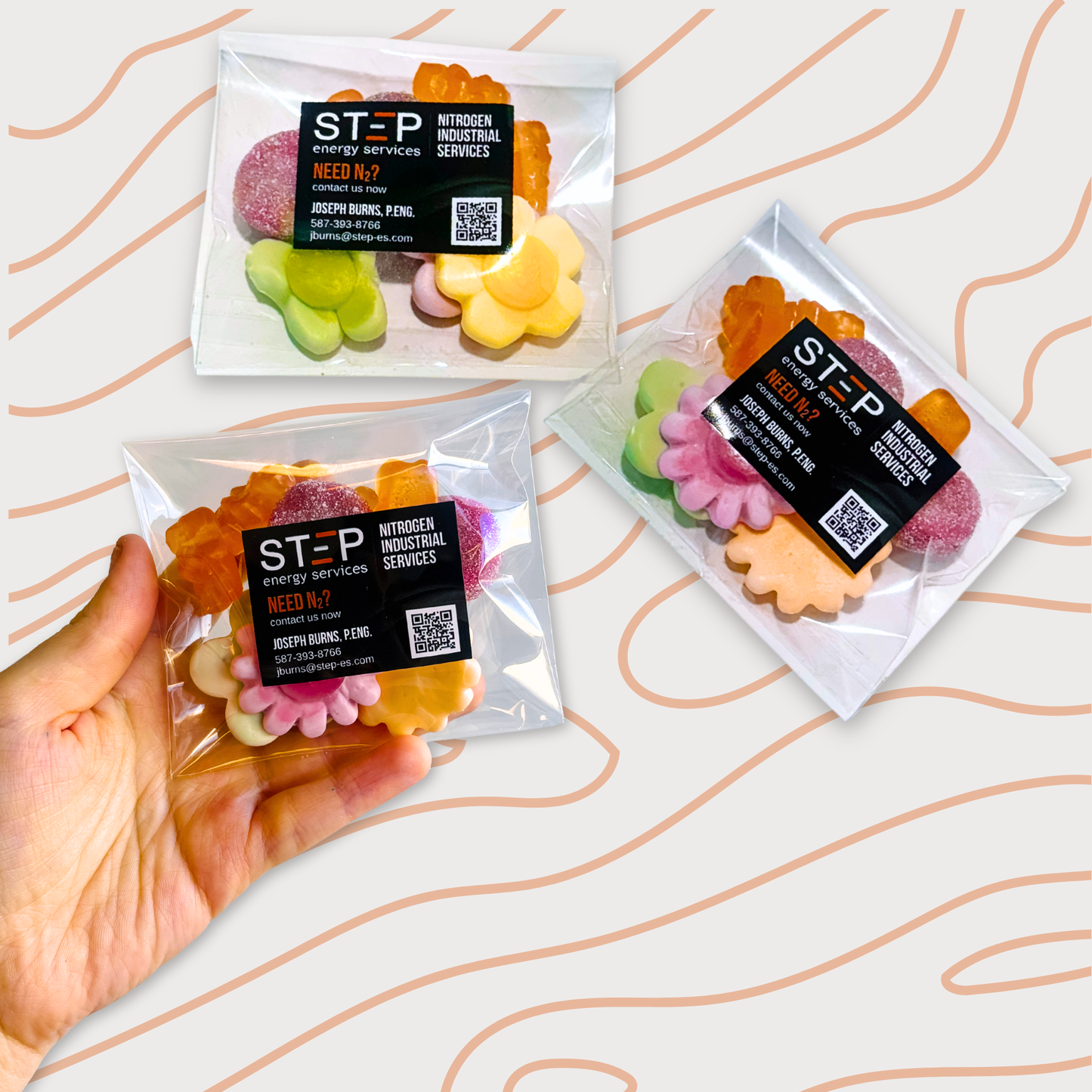 Branded candy bags filled with a pastel and orange candy mix, featuring a front logo sticker designed as a business card for STEP Energy Services.