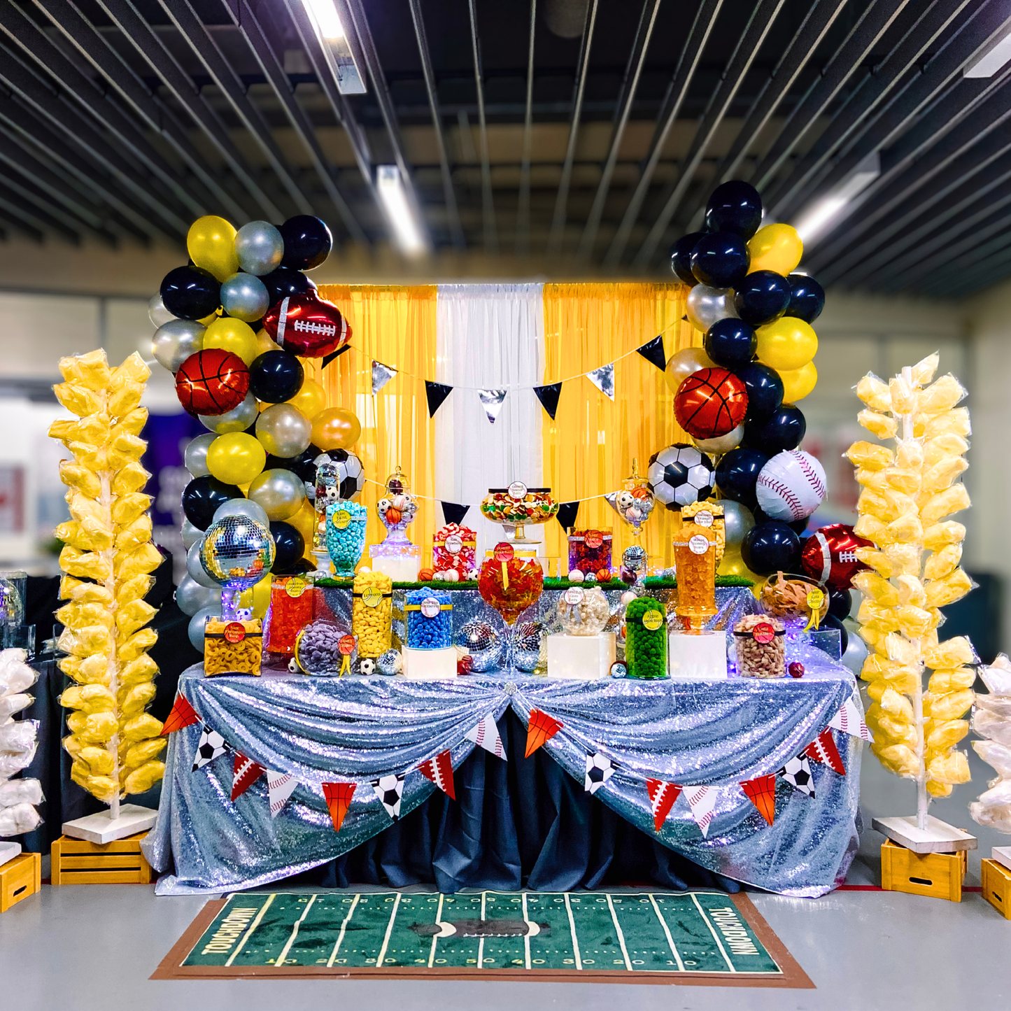 Large sports-themed candy buffet with colourful candy, balloons and a full event display