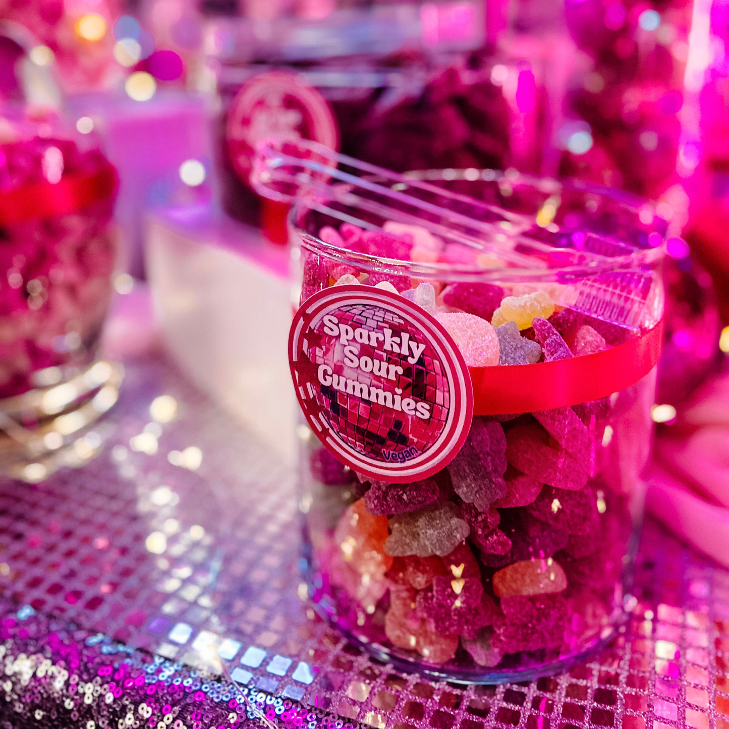 Colourful sour gummies displayed in a glass candy buffet jar with custom candy label