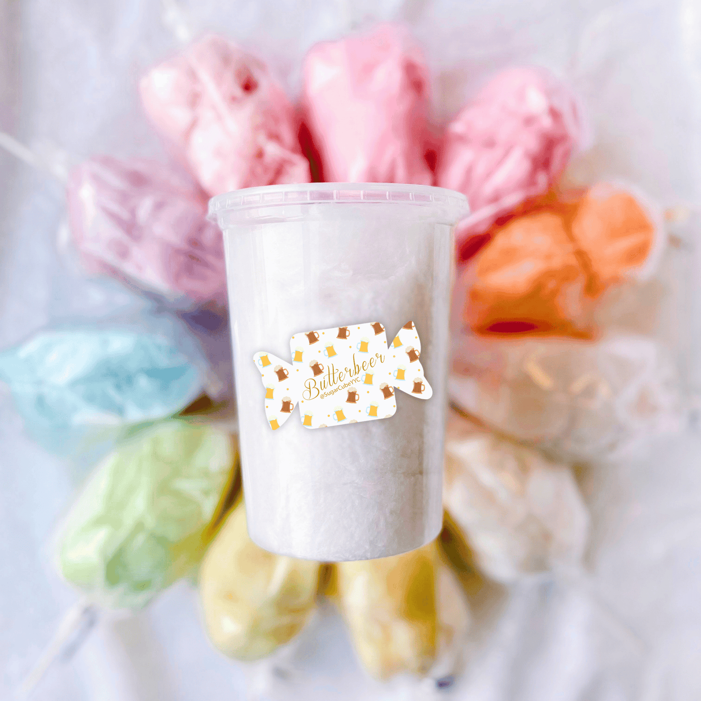 Butterbeer Cotton Candy Tub surrounded by fluffy cotton candy puffs