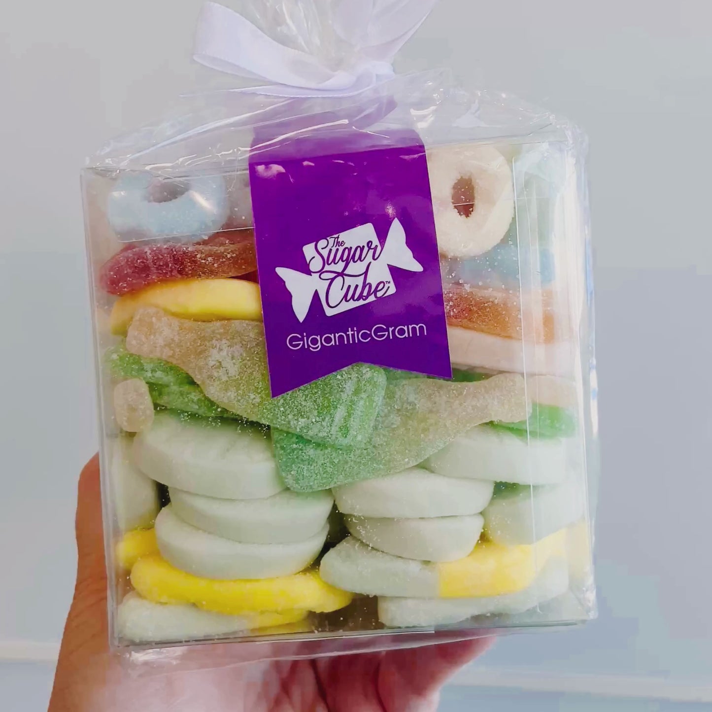 Load and play video in Gallery viewer, Hand holding and turning a Swedish CandyGram filled with assorted Swedish candy to show the front and side.
