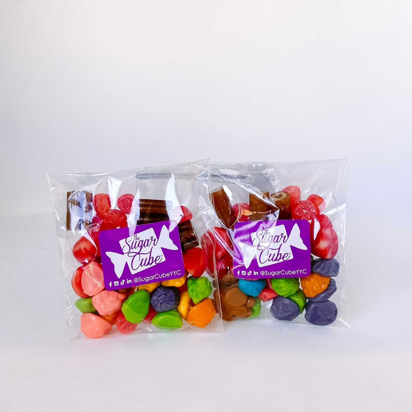 Two Rudolph's Stash holiday candy bags filled with festive red and brown candy including gummy carrots