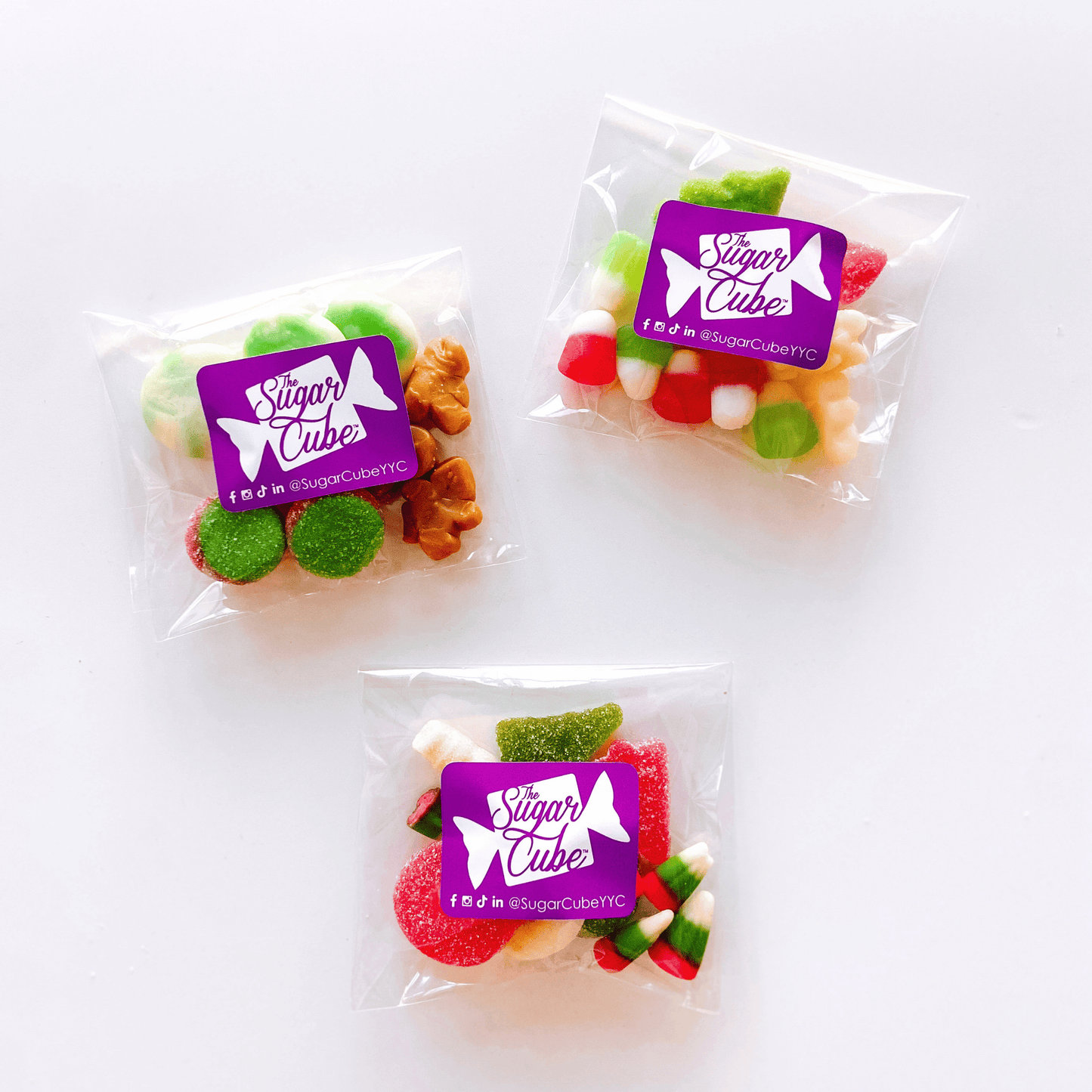 Spread the Cheer holiday candy bags grouped together with festive seasonal candy in Christmas colours