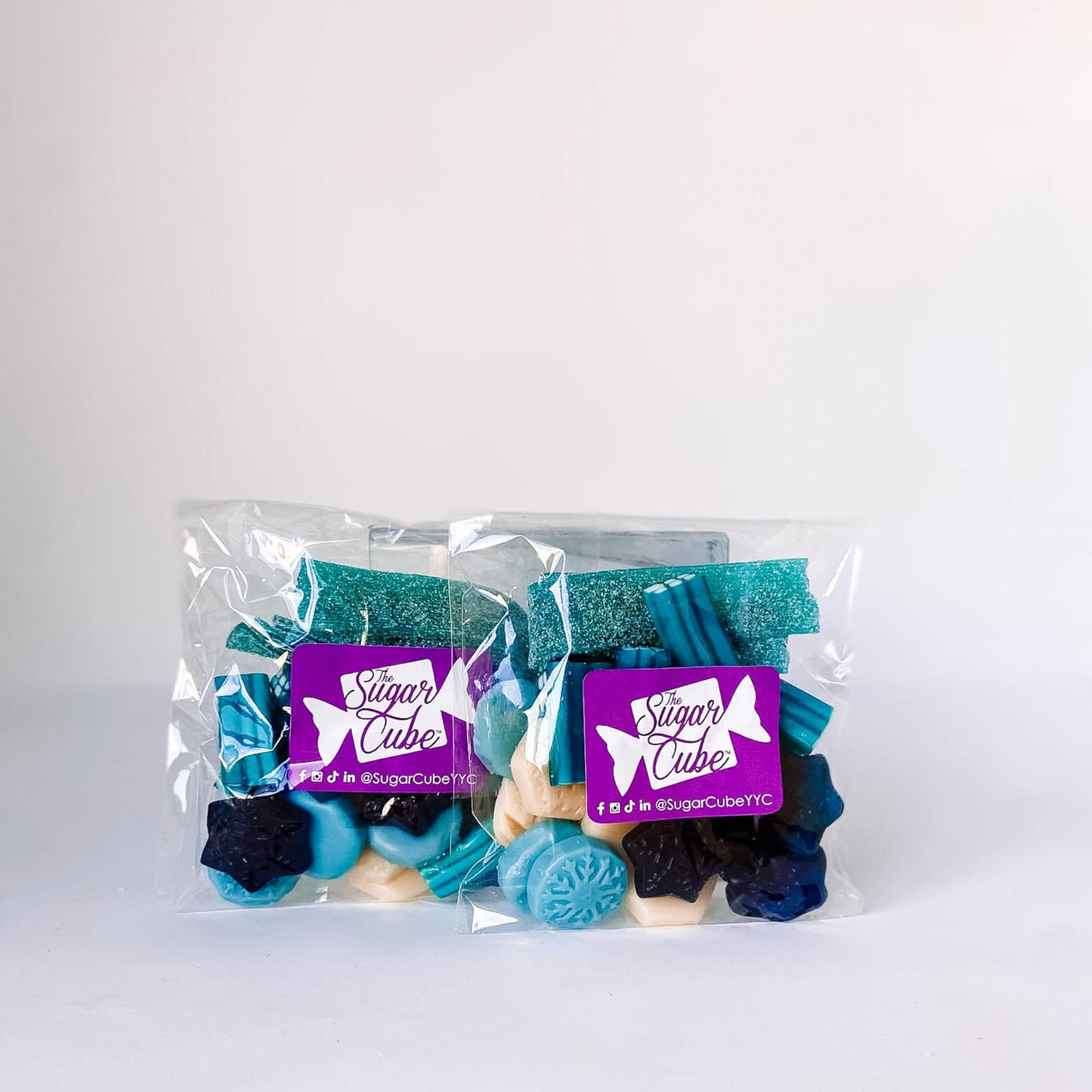 Two Winter Wonderland holiday candy bags featuring a frosty mix of blue and white seasonal sweets