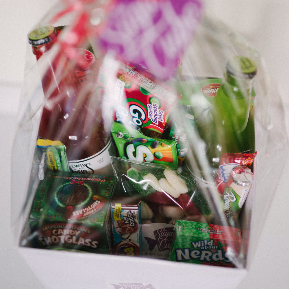 Christmas candy gift basket viewed from above, wrapped and filled with festive sweets, treats and specialty soda