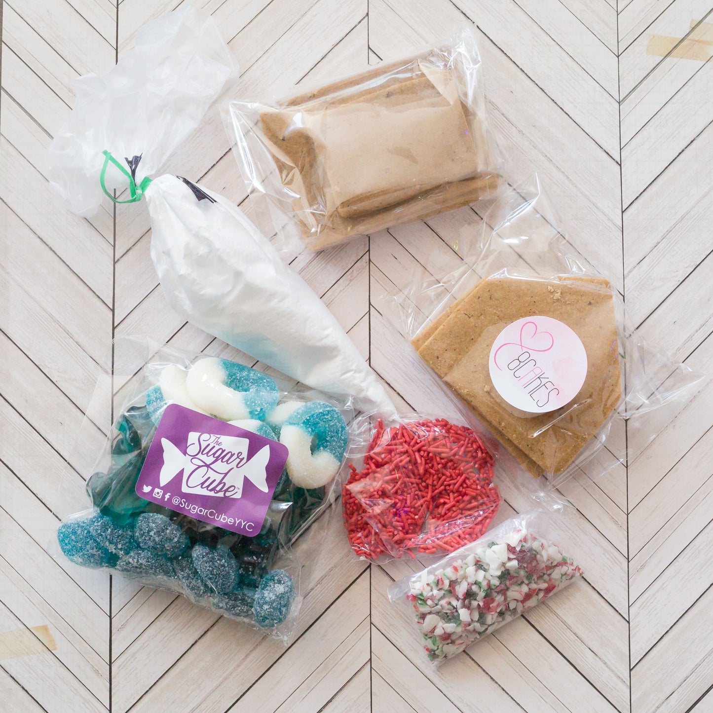 Christmas gingerbread house decorating kit with gingerbread pieces, icing and assorted candy laid out to show what's included